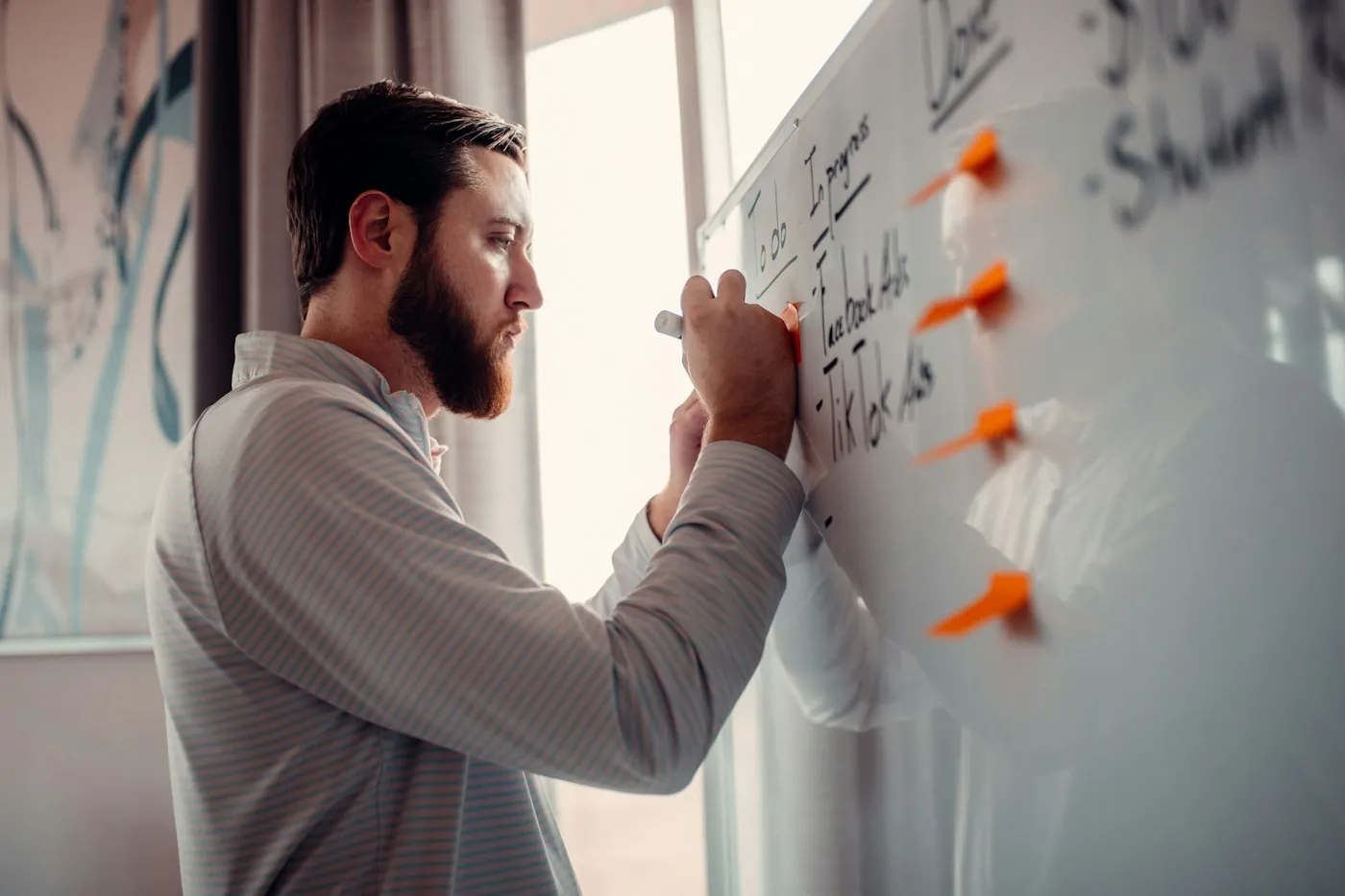 Strategist mapping a campaign plan with sticky notes on a whiteboard